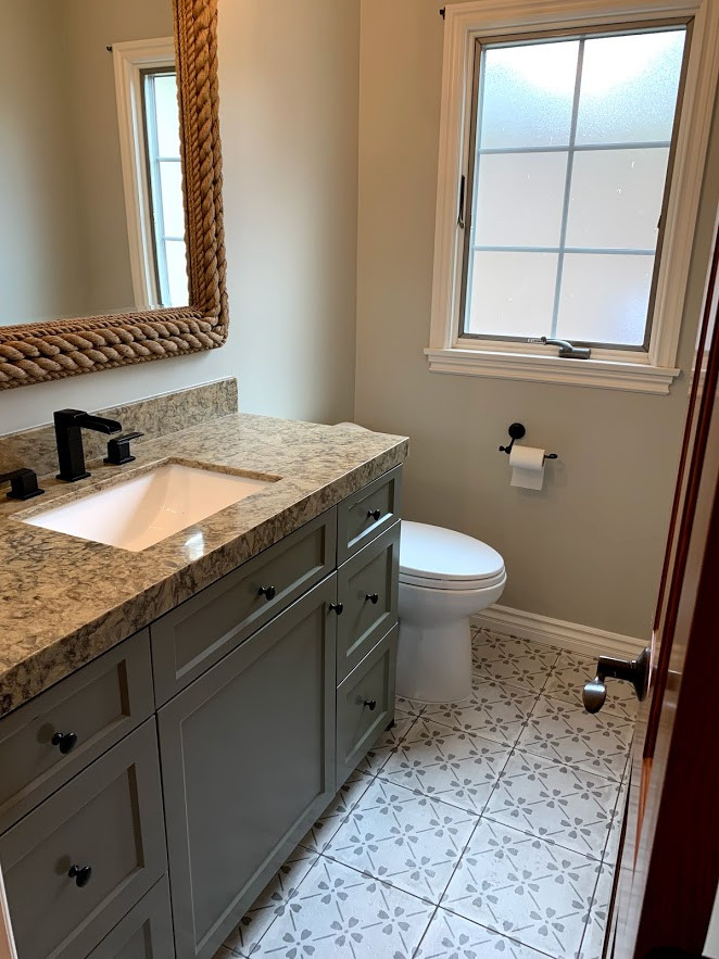 Medium sized classic shower room bathroom in Orange County with recessed-panel cabinets, green cabinets, a two-piece toilet, beige walls, mosaic tile flooring, a submerged sink, granite worktops, multi-coloured floors, multi-coloured worktops, a single sink and a built in vanity unit.