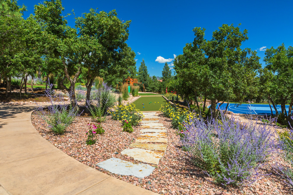 Geräumiger, Geometrischer Klassischer Garten hinter dem Haus, im Herbst mit Spielgerät, direkter Sonneneinstrahlung, Natursteinplatten und Metallzaun in Denver