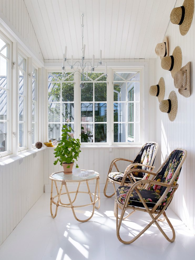 Photo of a mid-sized country sunroom in Stockholm with painted wood floors and a standard ceiling.