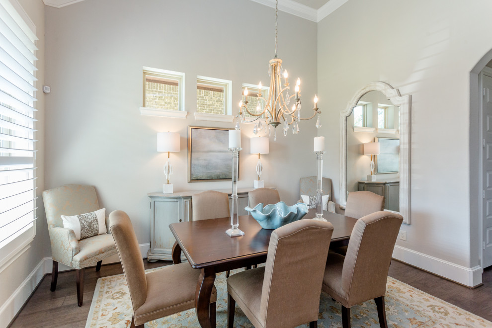 Photo of a mid-sized transitional separate dining room in Houston with grey walls and brown floor.