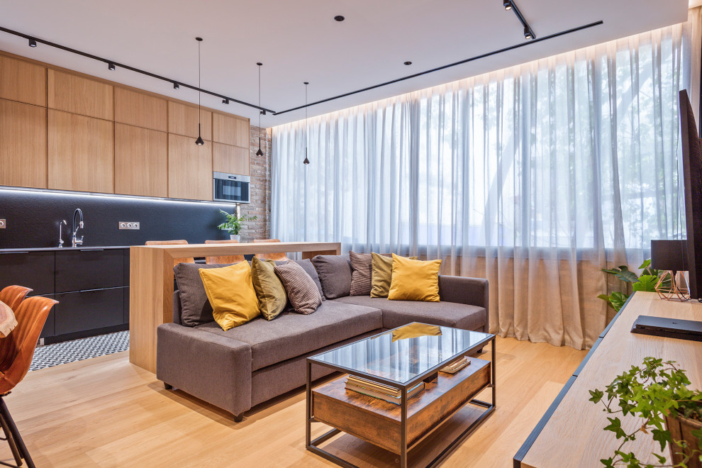 Ejemplo de sala de estar tipo loft urbana de tamaño medio con suelo de madera en tonos medios, televisor colgado en la pared y ladrillo