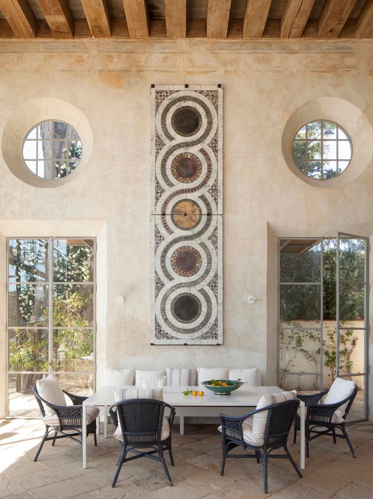 This is an example of a large mediterranean dining room in Los Angeles with limestone floors and beige walls.