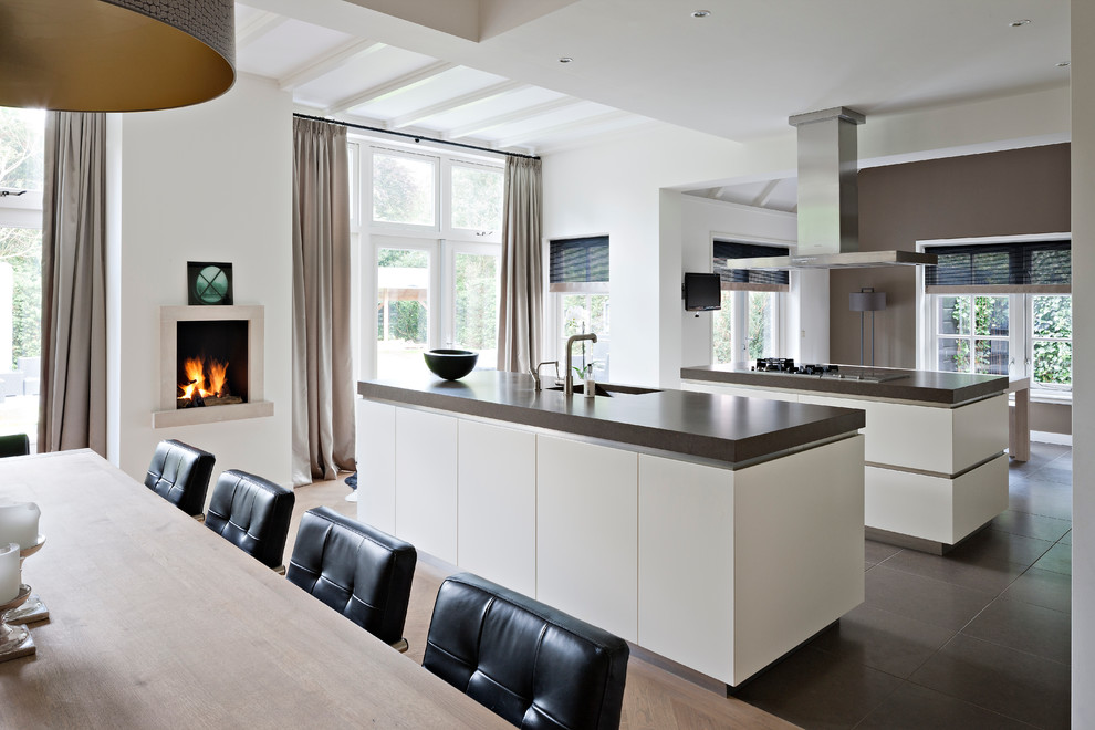 Contemporary eat-in kitchen in New York with flat-panel cabinets and white cabinets.