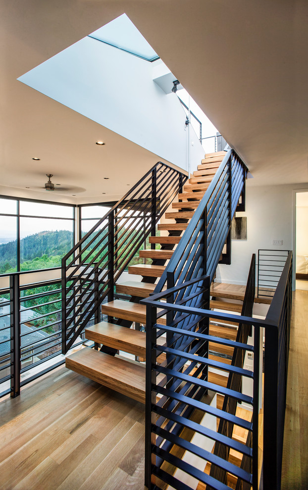 Modern wood floating staircase in Portland with open risers and metal railing.