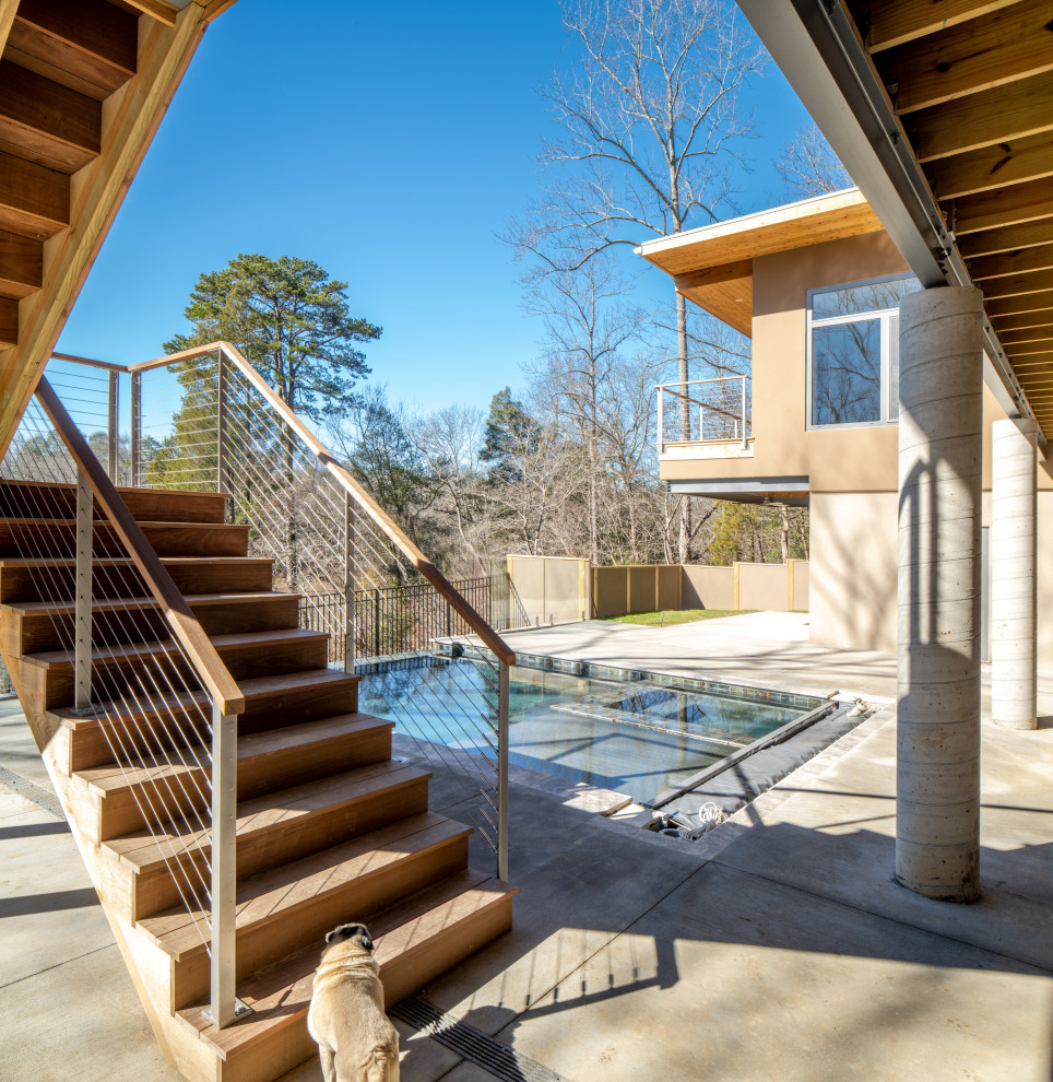 Huge minimalist stamped concrete screened-in and cable railing back porch photo in Raleigh with a roof extension
