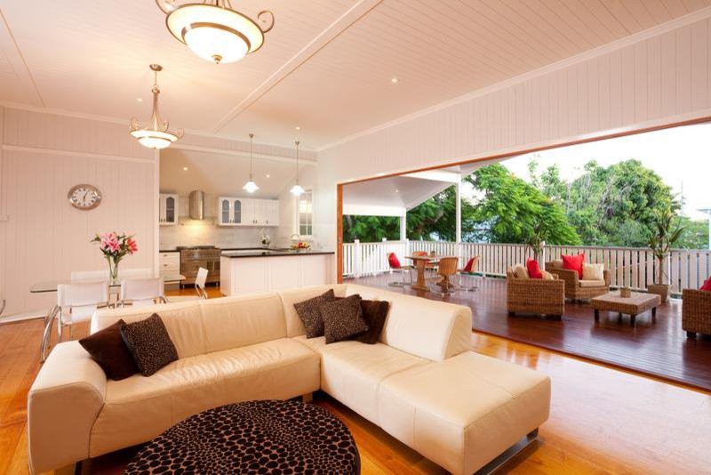 This is an example of a large country open concept family room in Brisbane with white walls and medium hardwood floors.