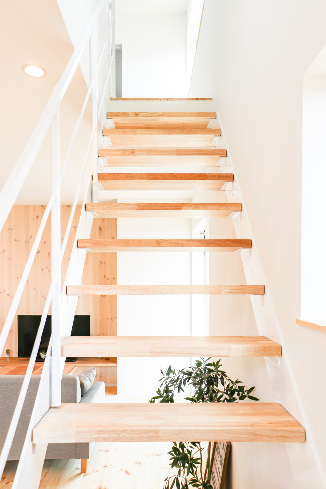 Источник вдохновения для домашнего уюта: лестница на больцах в стиле модернизм с деревянными ступенями, металлическими перилами и обоями на стенах без подступенок