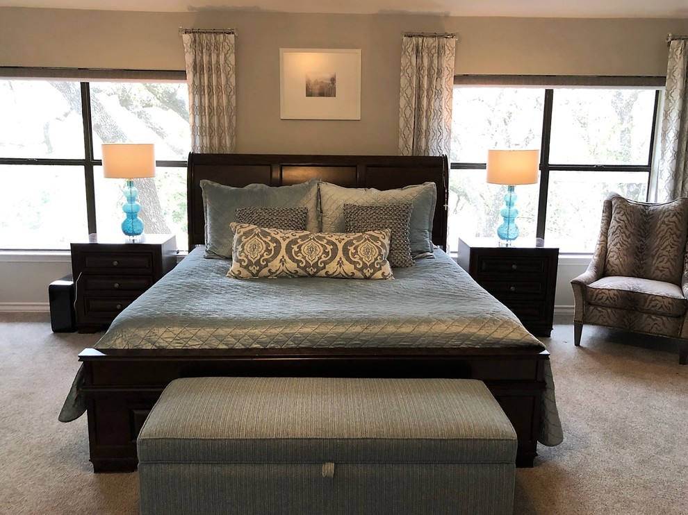 Photo of a large transitional master bedroom in Austin with grey walls, carpet, a standard fireplace, a plaster fireplace surround and grey floor.