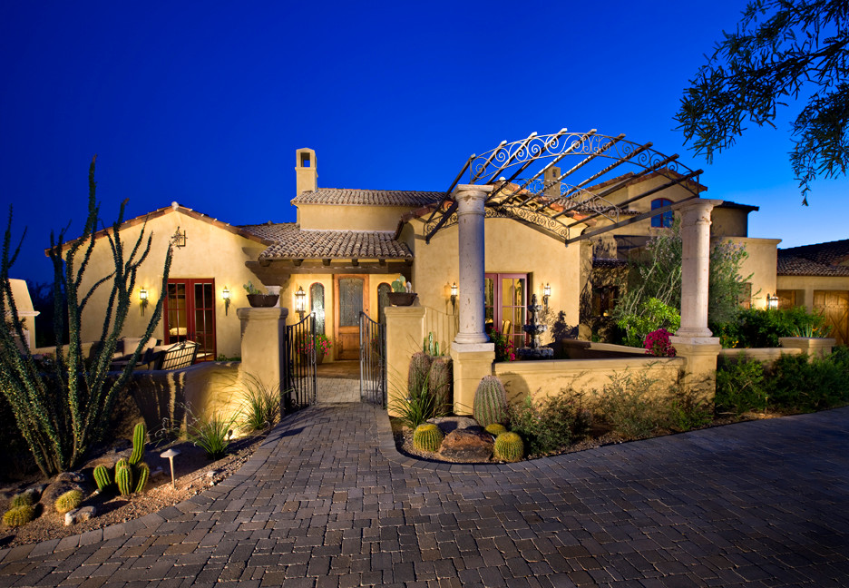 Design ideas for a mid-sized mediterranean one-storey adobe beige exterior in Phoenix with a gable roof.