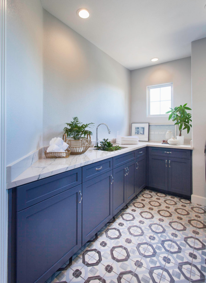 Idéer för att renovera en mellanstor funkis parallell tvättstuga enbart för tvätt, med släta luckor, blå skåp, vita väggar, klinkergolv i keramik och flerfärgat golv
