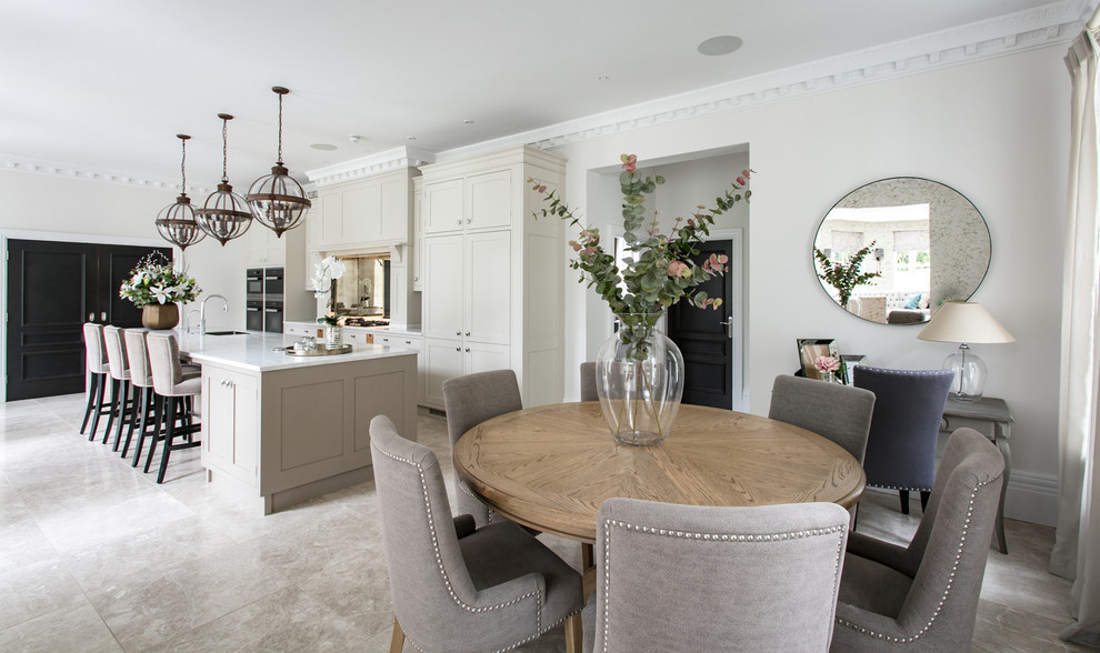 This is an example of a large traditional single-wall eat-in kitchen in Surrey with a drop-in sink, shaker cabinets, grey cabinets, solid surface benchtops, metallic splashback, glass sheet splashback, stainless steel appliances, marble floors, with island, grey floor and white benchtop.