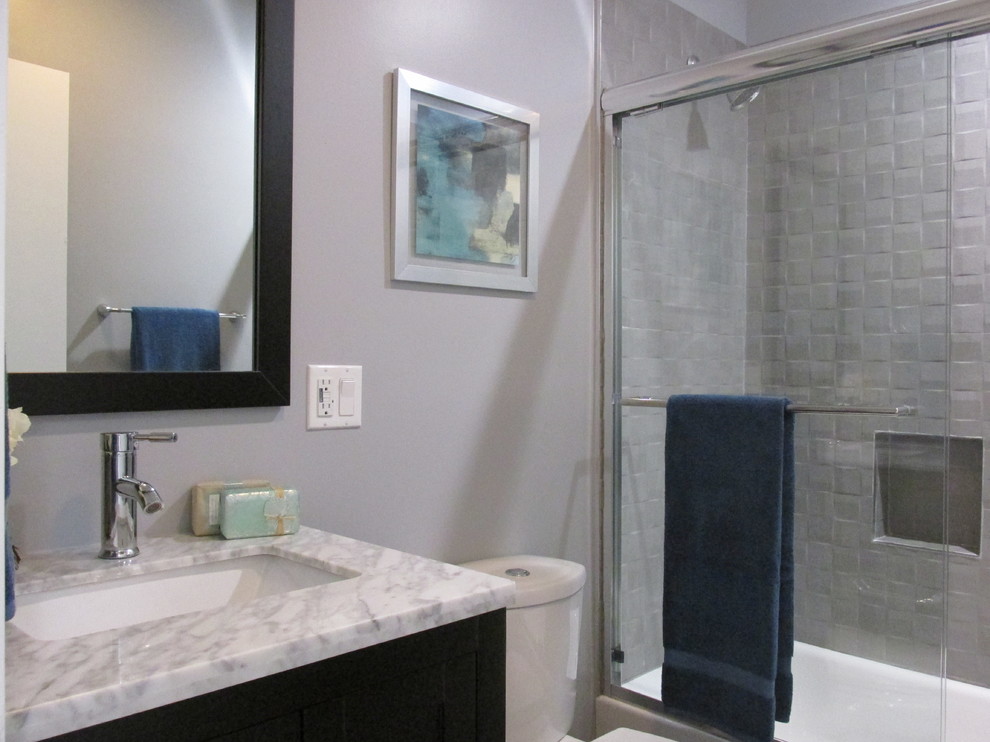 Inspiration for a mid-sized traditional 3/4 bathroom in Los Angeles with shaker cabinets, dark wood cabinets, an alcove tub, a shower/bathtub combo, gray tile, ceramic tile, grey walls, an undermount sink, quartzite benchtops and a sliding shower screen.
