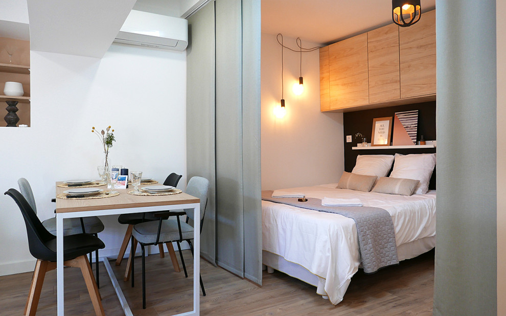 Foto de dormitorio principal mediterráneo de tamaño medio con paredes multicolor, suelo laminado y vigas vistas