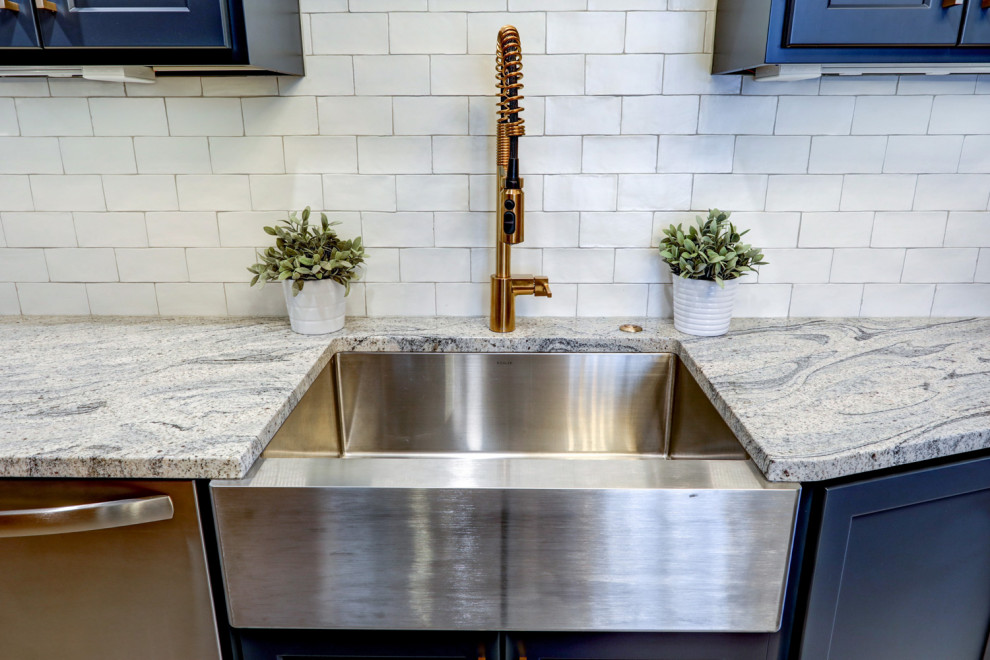 Inspiration for a mid-sized transitional l-shaped vinyl floor and gray floor kitchen pantry remodel with a farmhouse sink, recessed-panel cabinets, blue cabinets, granite countertops, white backsplash, subway tile backsplash, stainless steel appliances, no island and gray countertops