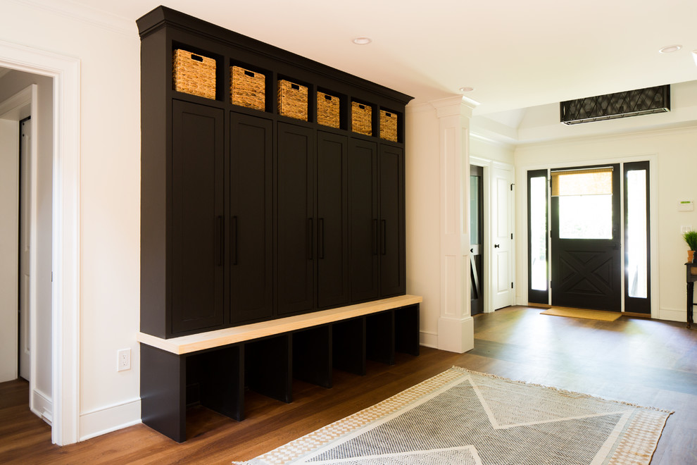 Photo of a small transitional mudroom in Raleigh with white walls, medium hardwood floors, a single front door, a black front door and brown floor.
