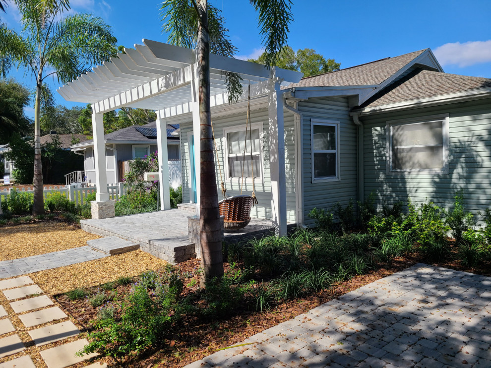 This is an example of a mid-sized coastal drought-tolerant and partial sun front yard concrete paver and vinyl fence garden path in Tampa for summer.