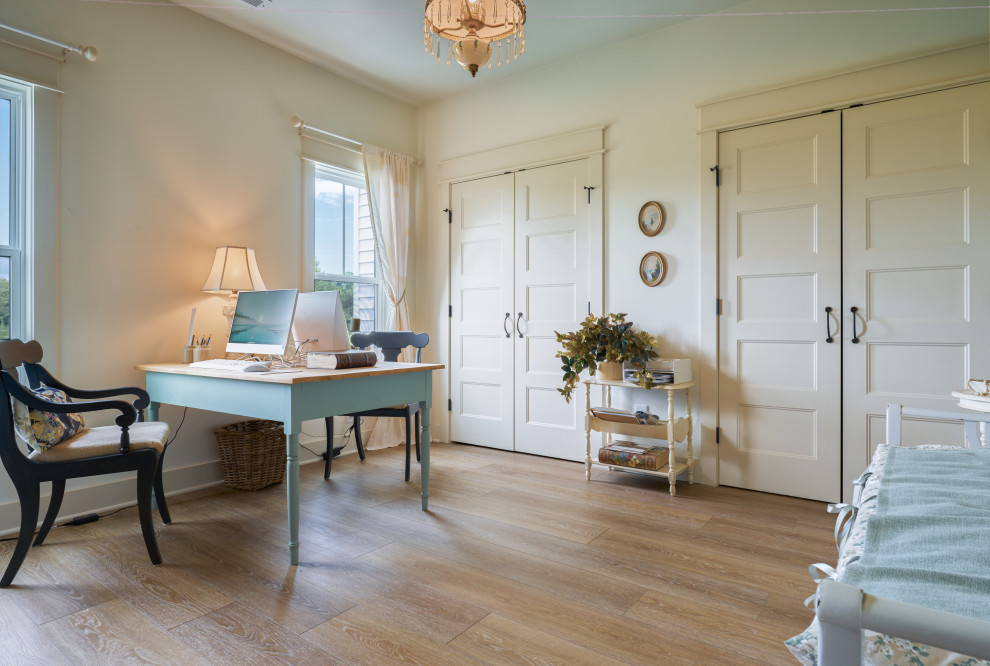 Modelo de despacho abovedado romántico de tamaño medio sin chimenea con paredes blancas, suelo vinílico, escritorio independiente, suelo beige y papel pintado