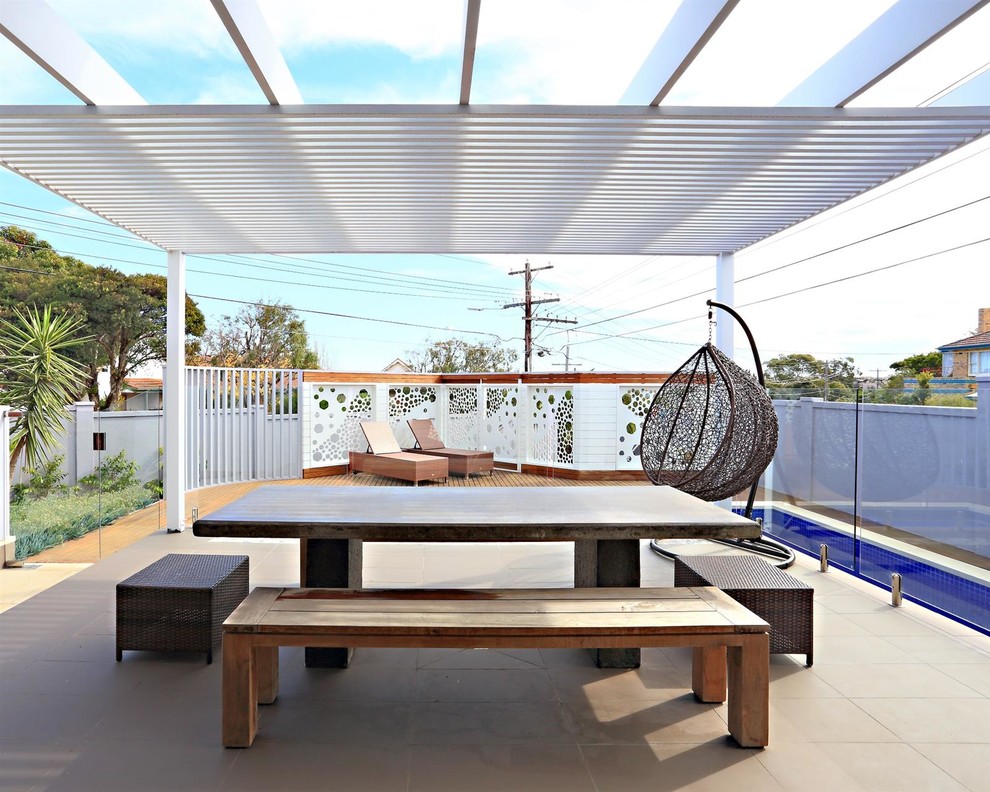Design ideas for a mid-sized modern backyard patio in Melbourne with tile and a roof extension.