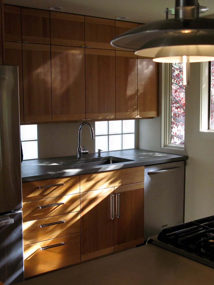Example of a small transitional galley ceramic tile open concept kitchen design in Seattle with an undermount sink, flat-panel cabinets, medium tone wood cabinets, concrete countertops, gray backsplash, glass tile backsplash, stainless steel appliances and a peninsula