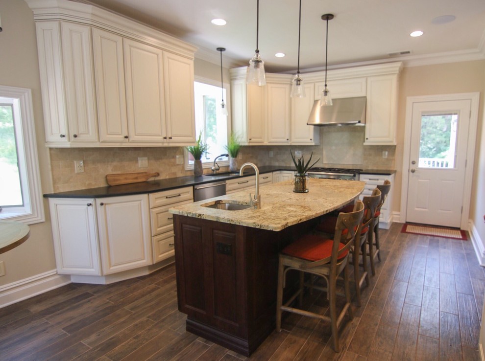Example of a mid-sized mountain style l-shaped dark wood floor and brown floor eat-in kitchen design in New York with an undermount sink, raised-panel cabinets, white cabinets, quartzite countertops, beige backsplash, stainless steel appliances, an island and beige countertops