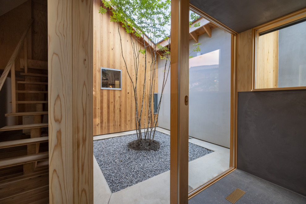 Ispirazione per un giardino minimalista esposto in pieno sole di medie dimensioni e in cortile in estate con ghiaia e recinzione in legno
