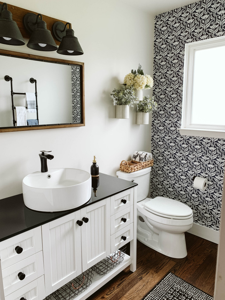 Inspiration for a small country 3/4 bathroom in Detroit with beaded inset cabinets, white cabinets, multi-coloured walls, dark hardwood floors, black benchtops, an enclosed toilet, a single vanity, a freestanding vanity and wallpaper.