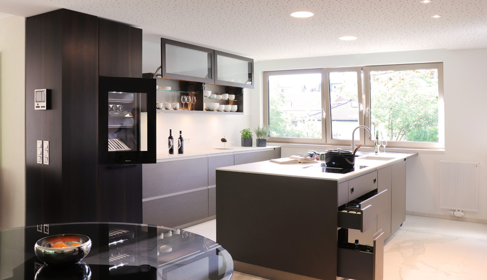 Design ideas for a large contemporary galley open plan kitchen in Frankfurt with an integrated sink, flat-panel cabinets, green cabinets, tile benchtops, white splashback, stainless steel appliances, marble floors, with island, white floor and white benchtop.