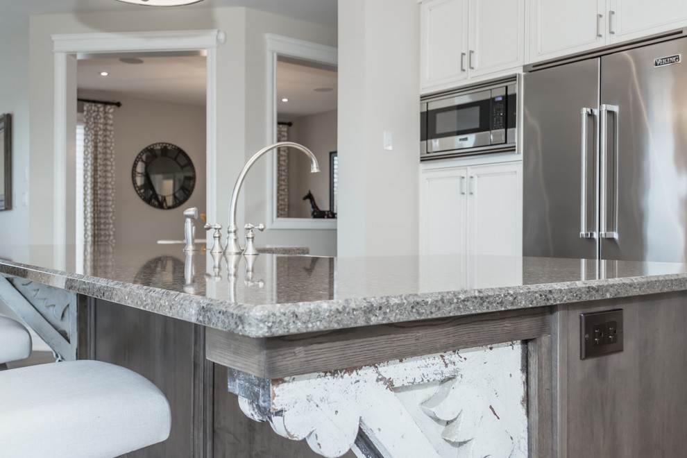 Inspiration for a large transitional porcelain tile kitchen remodel in Toronto with a farmhouse sink, white cabinets, quartz countertops, gray backsplash, ceramic backsplash, stainless steel appliances and an island