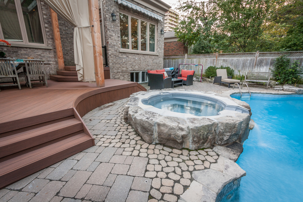 Example of a mid-sized transitional backyard deck design in Toronto with a pergola