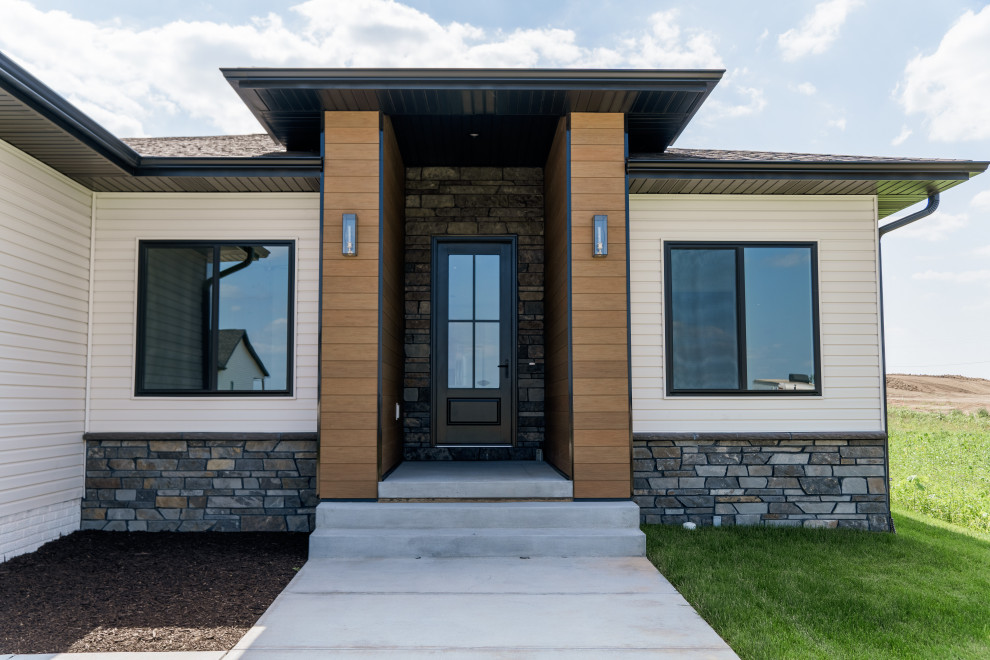 Front door - transitional concrete floor and wood wall front door idea with brown walls and a black front door