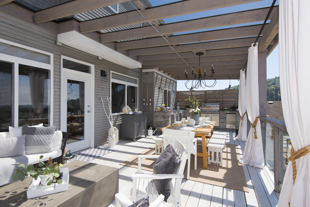 Large transitional backyard outdoor kitchen deck photo in Vancouver with a pergola