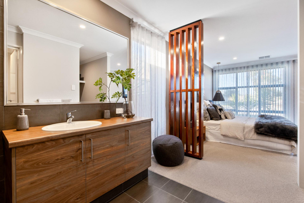 This is an example of a contemporary master bathroom in Perth with flat-panel cabinets, medium wood cabinets, gray tile, grey walls, a drop-in sink, wood benchtops, grey floor and brown benchtops.