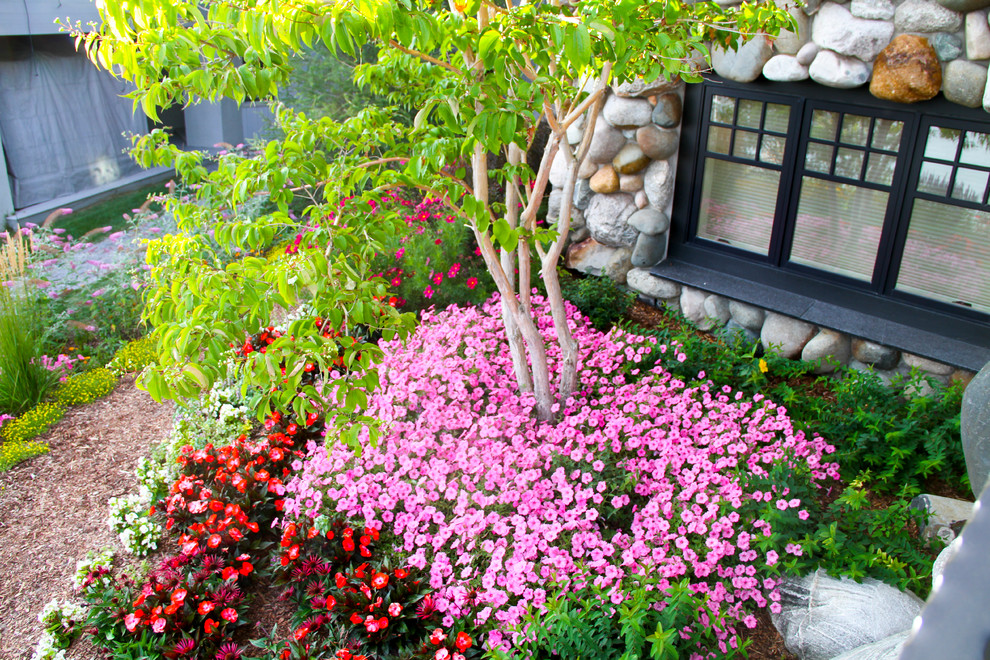 Inspiration for a large transitional backyard formal garden with a retaining wall and natural stone pavers.
