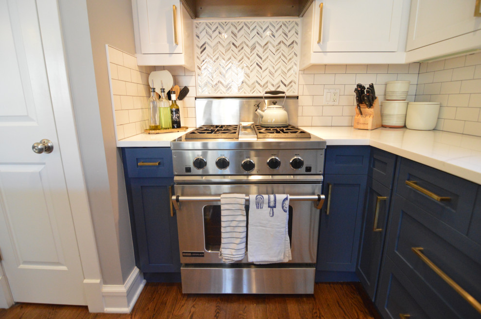 Example of a mid-sized transitional l-shaped medium tone wood floor open concept kitchen design in Chicago with flat-panel cabinets, quartz countertops, white backsplash, ceramic backsplash, stainless steel appliances, an island and white countertops