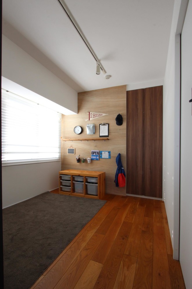 Diseño de habitación de niño de 1 a 3 años minimalista de tamaño medio con paredes multicolor, suelo de madera pintada y suelo marrón