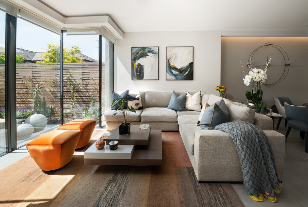This is an example of a contemporary living room in London with beige walls and grey floor.