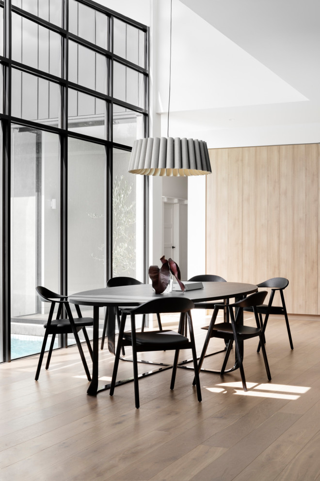 Inspiration for a contemporary open plan dining in Melbourne with white walls, light hardwood floors and beige floor.