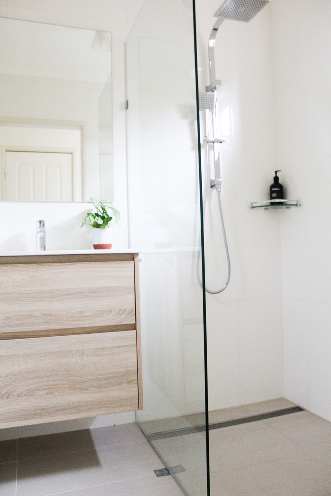 Small 3/4 bathroom in Perth with flat-panel cabinets, light wood cabinets, an open shower, a one-piece toilet, beige tile, ceramic tile, beige walls, porcelain floors, an integrated sink, solid surface benchtops, beige floor, an open shower and white benchtops.