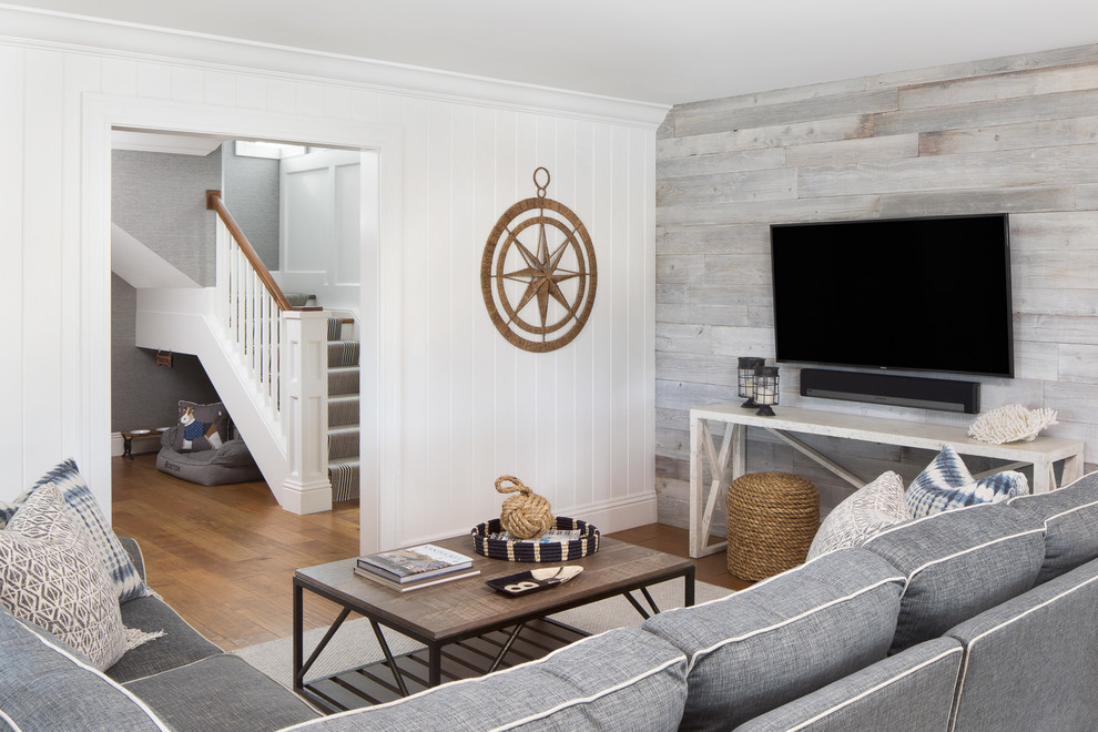 Mid-sized beach style open concept medium tone wood floor and brown floor family room photo in Miami with white walls, a wall-mounted tv and no fireplace