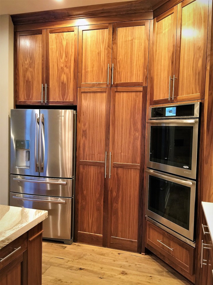 Eat-in kitchen - large transitional u-shaped light wood floor and brown floor eat-in kitchen idea in Omaha with an undermount sink, shaker cabinets, medium tone wood cabinets, quartz countertops, white backsplash, subway tile backsplash, stainless steel appliances, an island and white countertops