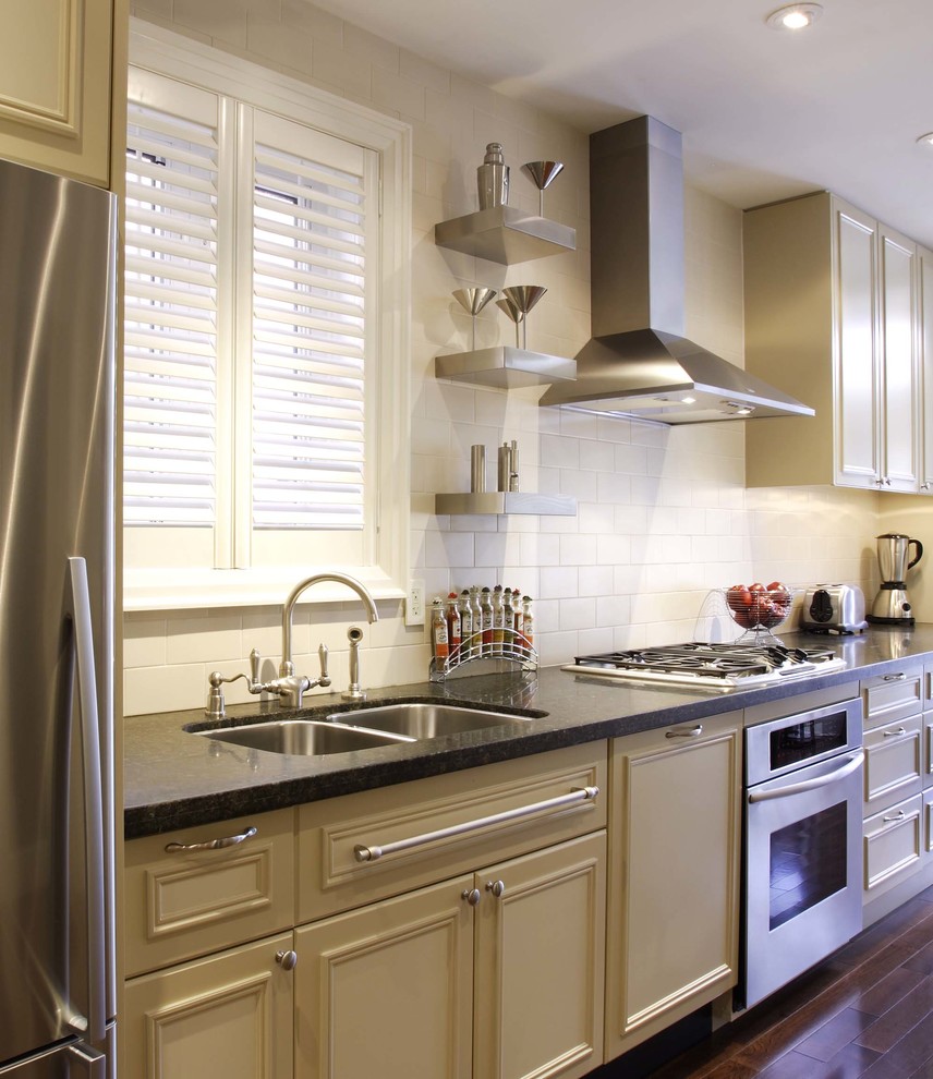 Eat-in kitchen - small transitional galley medium tone wood floor eat-in kitchen idea in Toronto with an undermount sink, raised-panel cabinets, beige cabinets, granite countertops, beige backsplash, porcelain backsplash, stainless steel appliances and no island