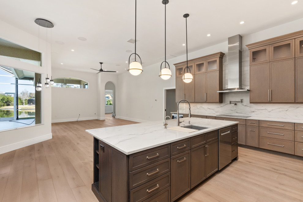 Example of a large transitional galley light wood floor and brown floor eat-in kitchen design in Tampa with a double-bowl sink, shaker cabinets, dark wood cabinets, quartz countertops, gray backsplash, stone slab backsplash, stainless steel appliances, an island and gray countertops