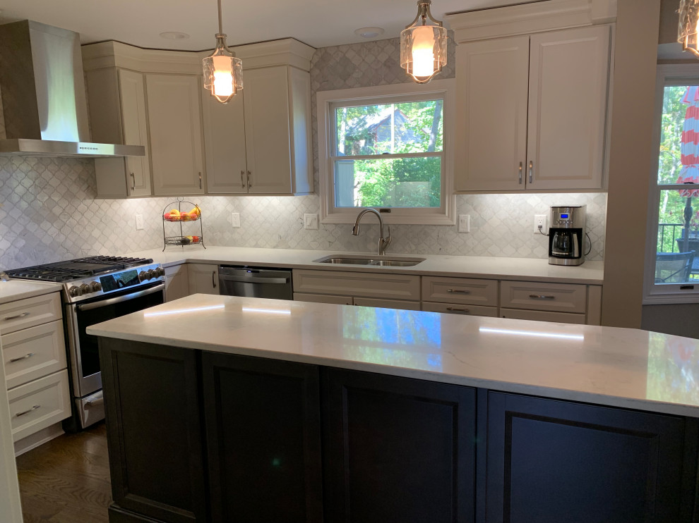 Mid-sized transitional l-shaped medium tone wood floor and brown floor eat-in kitchen photo in Cincinnati with an undermount sink, flat-panel cabinets, white cabinets, quartz countertops, white backsplash, marble backsplash, stainless steel appliances, an island and white countertops