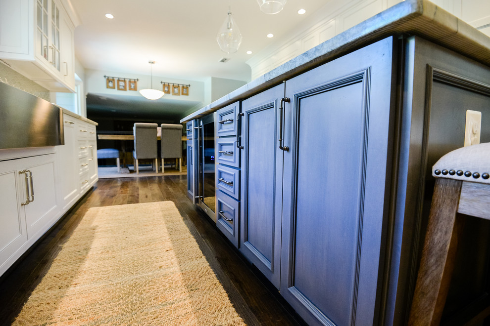 Inspiration for a large transitional u-shaped medium tone wood floor and brown floor eat-in kitchen remodel in DC Metro with a farmhouse sink, recessed-panel cabinets, white cabinets, marble countertops, stainless steel appliances and an island