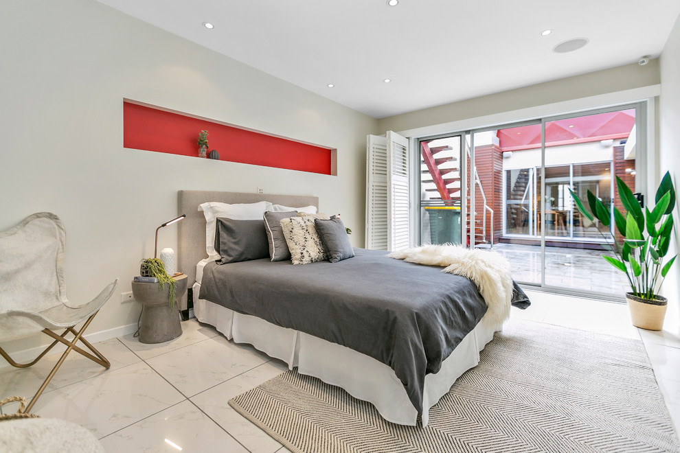 This is an example of a contemporary bedroom in Hobart with beige walls and white floor.