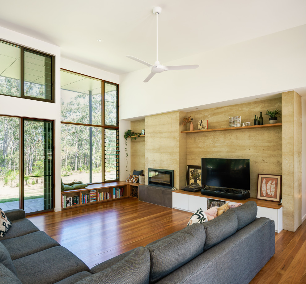 Cette image montre un salon design avec un mur blanc, un sol en bois brun, une cheminée ribbon, un téléviseur indépendant et un sol marron.