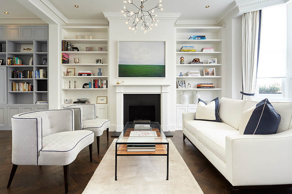 This is an example of a transitional formal living room in London with white walls, dark hardwood floors, a standard fireplace and brown floor.