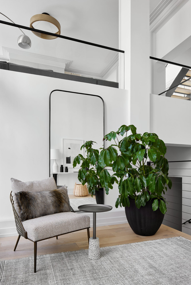 Immagine di un ingresso minimalista con pareti bianche, parquet chiaro e travi a vista