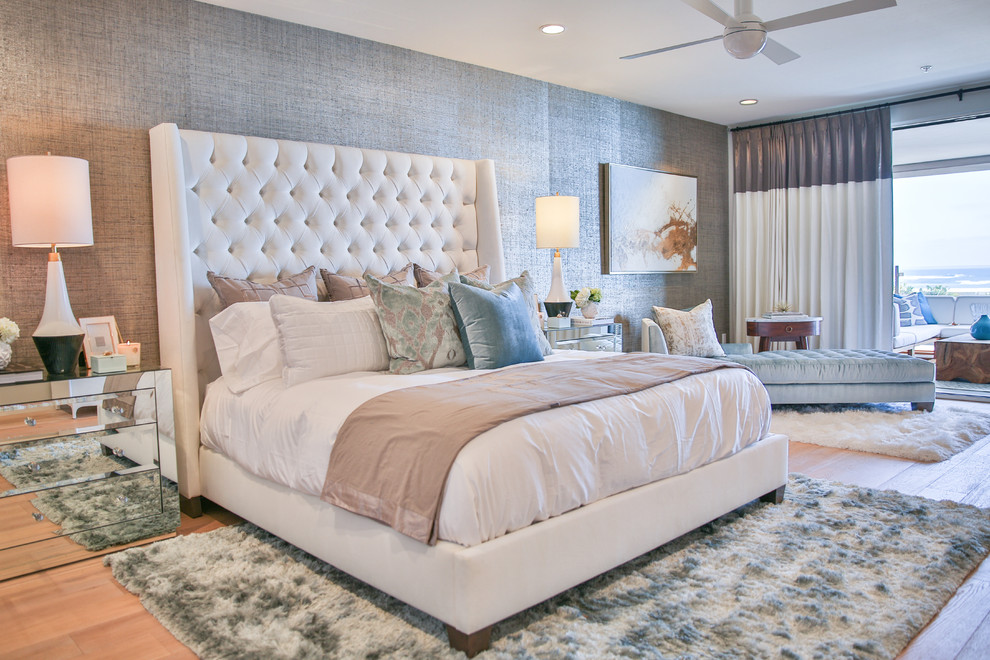 This is an example of a beach style bedroom in San Diego with grey walls, light hardwood floors and beige floor.