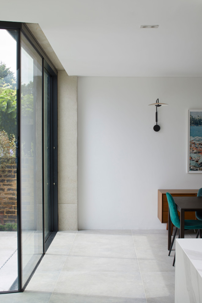 Esempio di una sala da pranzo aperta verso il soggiorno contemporanea con pavimento in cemento, pavimento grigio e pareti in mattoni